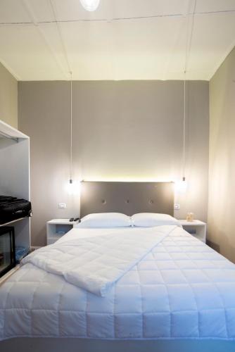 a bedroom with a large white bed with a large headboard at Boutique Hotel Palazzo Corso Umberto in Boiano