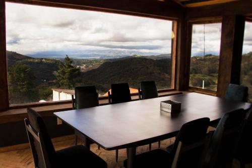 a table and chairs in a room with a large window at Hotel Santiurde SOLO ADULTOS in Mineral del Monte
