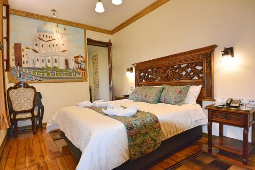 a hotel room with two beds and a table at Hotel La Basílica Quito in Quito