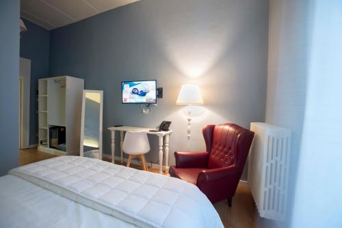 a bedroom with a bed and a chair and a desk at Boutique Hotel Palazzo Corso Umberto in Boiano