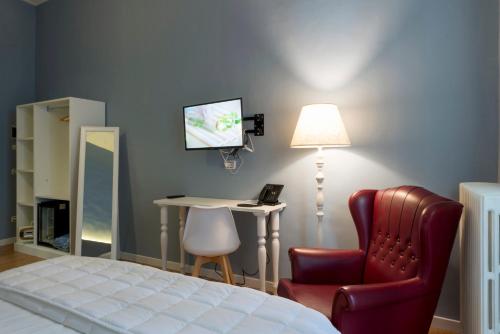 a bedroom with a bed and a chair and a desk at Boutique Hotel Palazzo Corso Umberto in Boiano