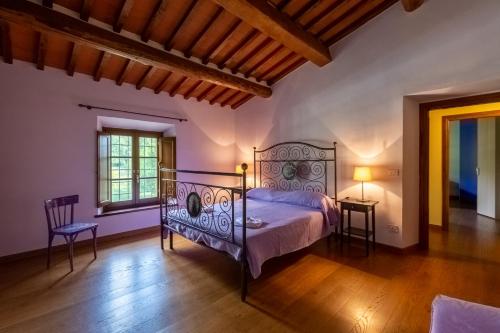 una camera da letto con un letto, due sedie e una finestra di Casa Gabry a Sarteano