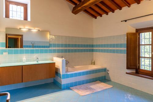 un bagno blu e bianco con vasca e lavandino di Casa Gabry a Sarteano