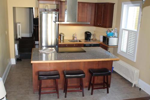 a kitchen with a counter and some stools in it at The Novel Stay in Halifax
