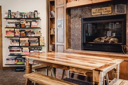 een woonkamer met een houten tafel en een open haard bij Park City Hostel in Park City