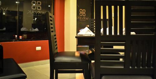 a black chair sitting in front of a restaurant at Wayak Hotel in Managua