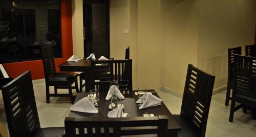 a dining room with tables and chairs with napkins at Wayak Hotel in Managua