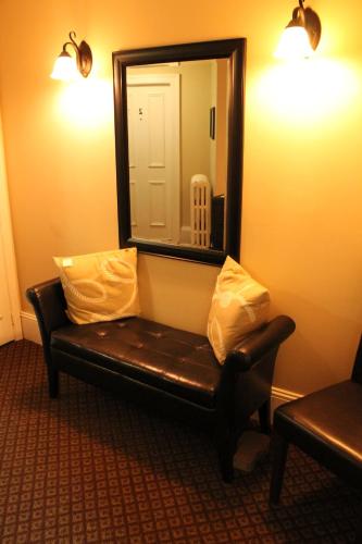 a mirror and a leather couch in a room at The Novel Stay in Halifax