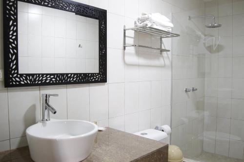 a white bathroom with a sink and a mirror at Hotel Varadero Internacional in Guayaquil