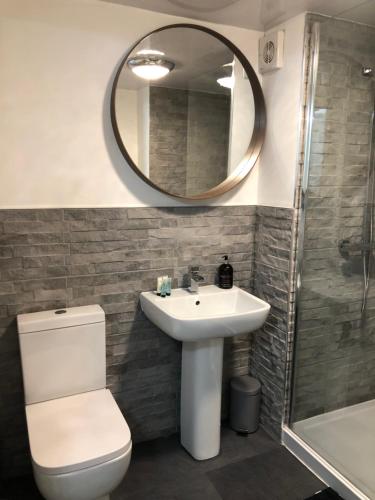 a bathroom with a toilet and a sink and a mirror at The Nook - Coorie Doon in Ayr