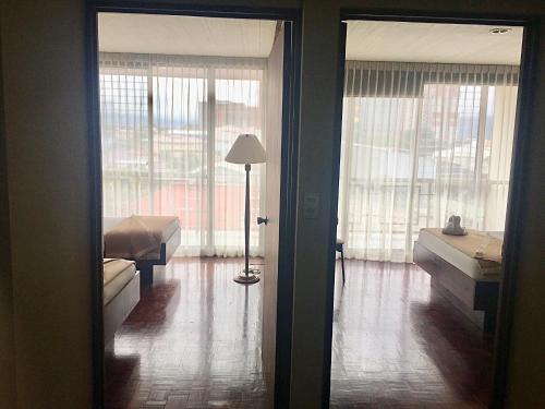 a room with two beds and a lamp in it at Hotel Ambassador in San José
