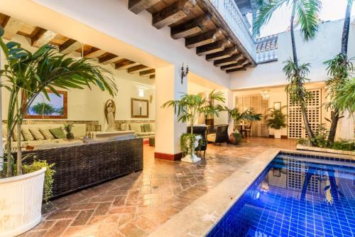 an indoor pool in a house with a tub and palm trees at Hotel Casa la Tablada in Cartagena de Indias