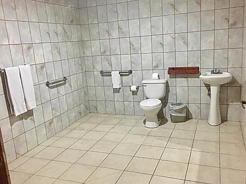 a bathroom with a toilet and a sink at Hotel Ambassador in San José