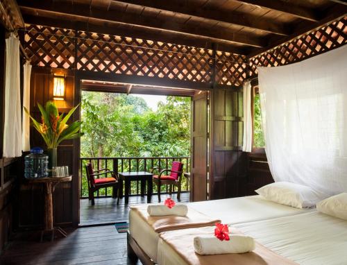 um quarto com uma cama e uma varanda em Our Jungle House em Khao Sok