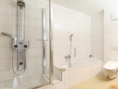 e bagno con doccia, vasca e servizi igienici. di Haus König a Bezau