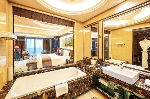 a bathroom with a tub and a bed in a room at Howard Johnson Agile Plaza Chengdu in Chengdu