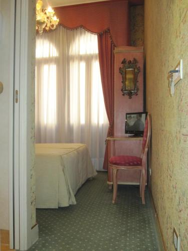 a room with a bed and a table and a chair at Locanda Ca' del Brocchi in Venice
