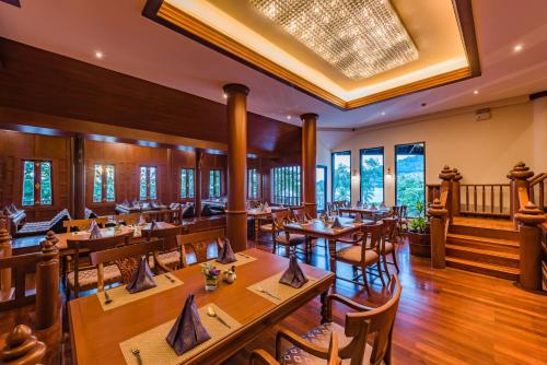 a restaurant with wooden tables and chairs at Diamond Cliff Resort & Spa, Patong Beach in Patong Beach