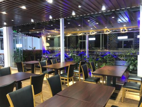 a restaurant with wooden tables and chairs and plants at Doha 2 Hotel Saigon Airport in Ho Chi Minh City