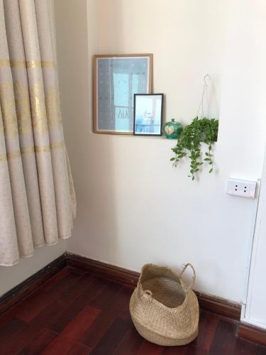 a room with a basket on the floor and a window at Khai Homestay in Hanoi