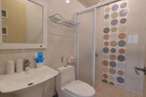 a bathroom with a toilet and a sink and a shower at 銤海民宿 電梯附設停車場 in Jian