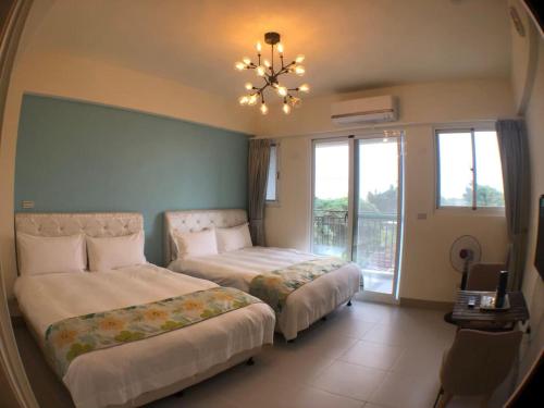 una camera da letto con due letti e un lampadario di Mi Hai B&B a Ji'an