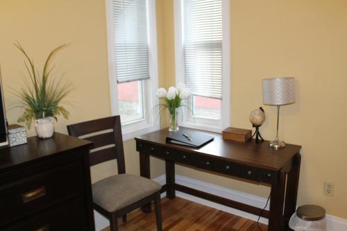 an office with a desk and a chair and a table with flowers at The Novel Stay in Halifax