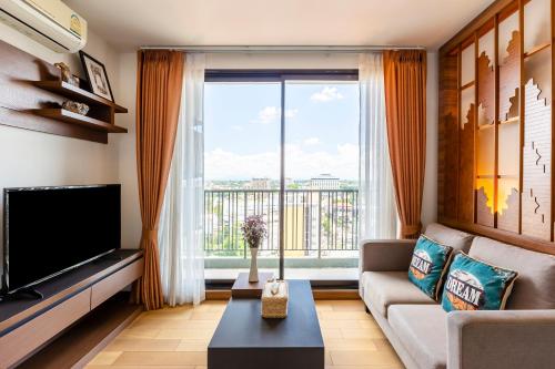 a living room with a couch and a large window at Anta Residence ''Self-sevice apartment'' in Chiang Mai