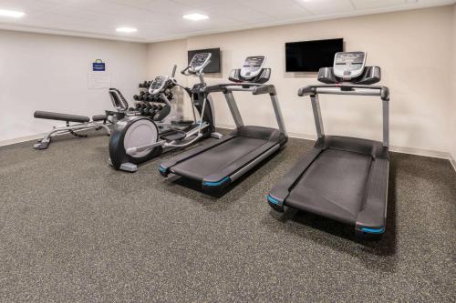 a gym with two exercise bikes and a flat screen tv at Days Inn & Suites by Wyndham Duluth by the Mall in Duluth