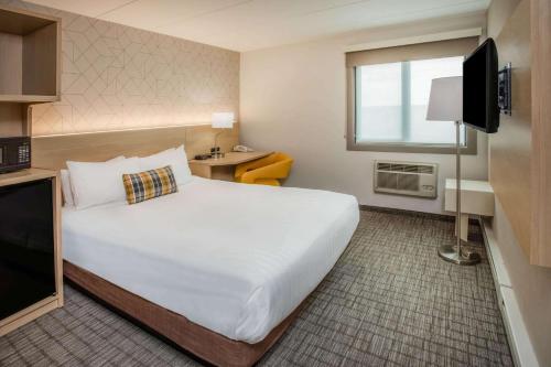 Days Inn & Suites by Wyndham Duluth by the Mall tesisinde bir odada yatak veya yataklar
