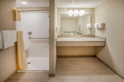 y baño con lavabo y espejo. en Days Inn & Suites by Wyndham Duluth by the Mall en Duluth