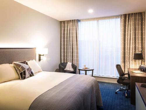 a hotel room with a bed and a window at Mercure Bridgwater in Bridgwater