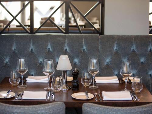 a wooden table with wine glasses and napkins at Mercure Bridgwater in Bridgwater