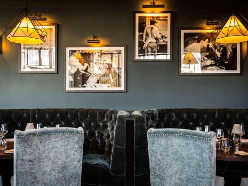 a restaurant with a leather couch and pictures on the wall at Mercure Bridgwater in Bridgwater