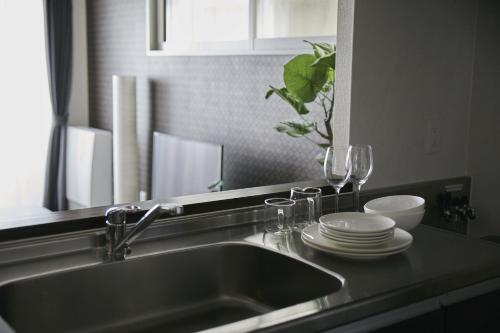 a kitchen sink with plates and wine glasses on it at PINN-N4E2Ⅰ in Sapporo