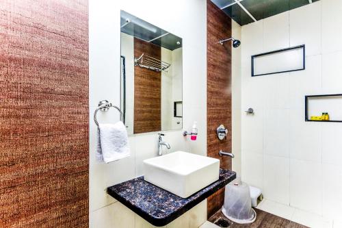 a bathroom with a sink and a mirror at FabHotel Imperio - Nr Baner Hill in Pune