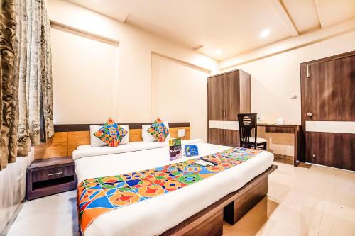 a bedroom with a bed and a desk and a chair at FabHotel Imperio Baner in Pune