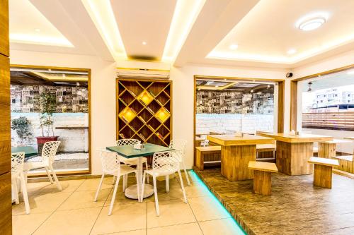 a restaurant with tables and chairs and wine bottles at FabHotel Imperio - Nr Baner Hill in Pune