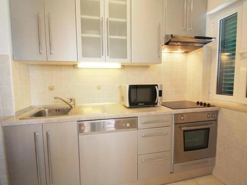 布雷拉的住宿－VILLA NEDE，厨房配有白色橱柜、水槽和微波炉
