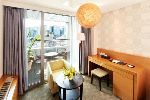 a hotel room with a desk and a large window at Hotel PJ Myeongdong in Seoul