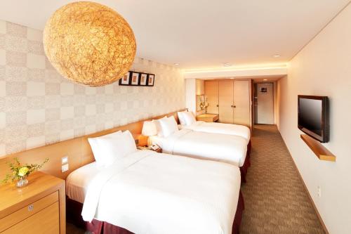 a hotel room with two beds and a television at Hotel PJ Myeongdong in Seoul