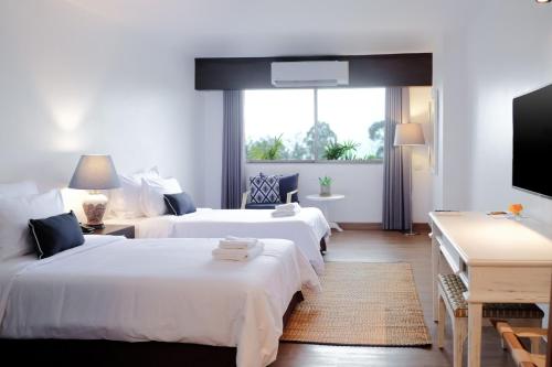清邁的住宿－La Mai Hotel，酒店客房设有两张床和一台平面电视。