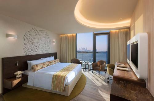 a hotel room with a bed and a large window at The Retreat Palm Dubai MGallery by Sofitel in Dubai