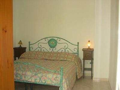 a bedroom with a bed and two night stands with a lamp at Hotel Pompeo Residence in Castellabate