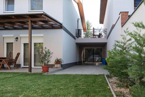 a house with a courtyard with a patio at Szíriusz Apartmanház in Gyula