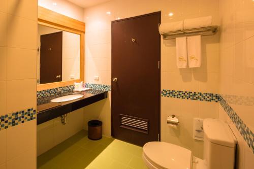 a bathroom with a toilet and a sink and a mirror at Sungthong Kamala Beach Resort in Kamala Beach