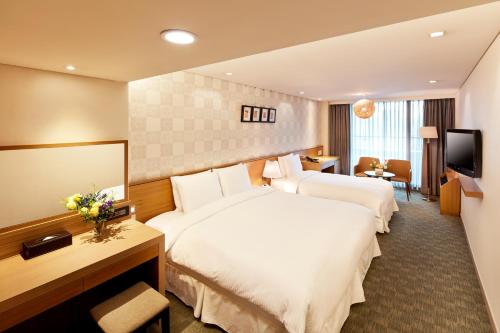 a hotel room with two beds and a television at Hotel PJ Myeongdong in Seoul