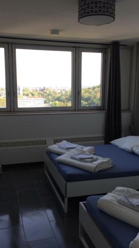 two beds in a room with two windows at FeWo Köln in Cologne