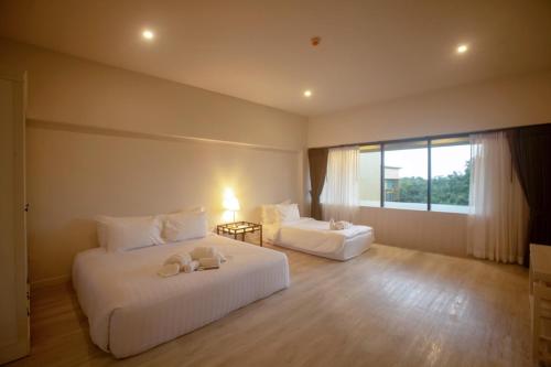 a hotel room with two beds and a window at TREX Buriram Boutique Hotel in Buriram