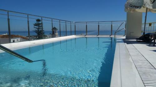 a swimming pool with a view of the ocean at Mena Plaza in Nerja